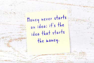 Ahşap duvardaki sarı yapışkan notta bilgece bir alıntı var.