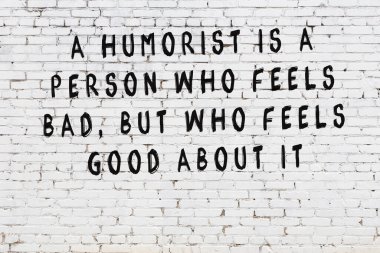 Beyaz tuğla duvar arkaplanına siyah düşünceli bir yazı.