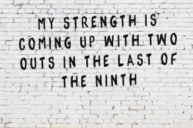 Beyaz tuğla duvar arkaplanına siyah düşünceli bir yazı.