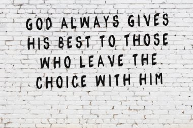 Beyaz tuğla duvara zekice alıntılar yazılı siyah bir yazı.