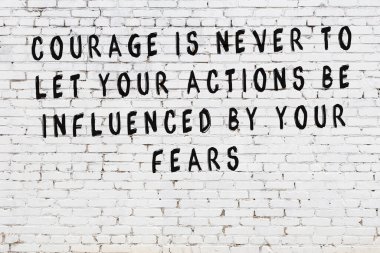 Beyaz tuğla duvar arkaplanına siyah düşünceli bir yazı.