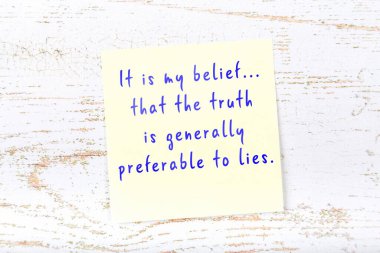 Ahşap duvardaki sarı yapışkan notta bilgece bir alıntı var.