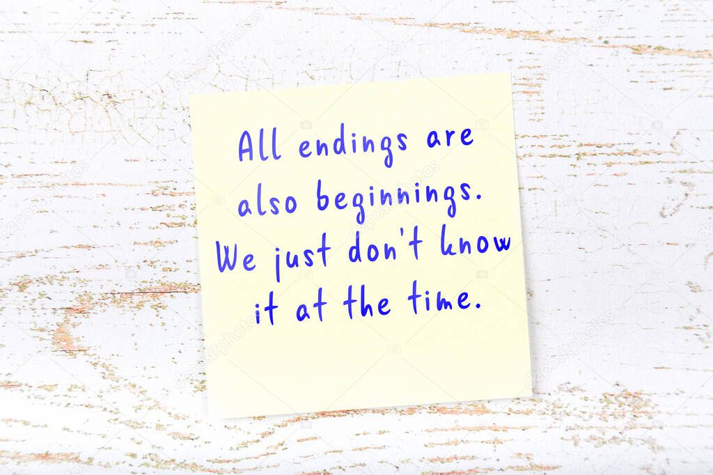 Yellow sticky note on wooden wall with wise quote