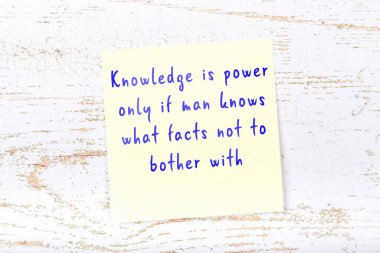 Ahşap duvardaki sarı yapışkan notta bilgece bir alıntı var.