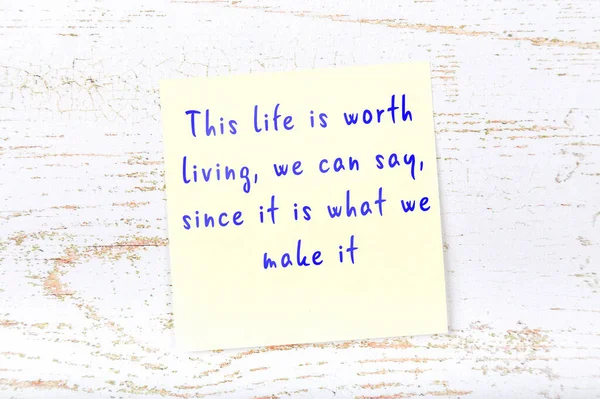 Yellow sticky note on wooden wall with wise quote — Stock Photo, Image