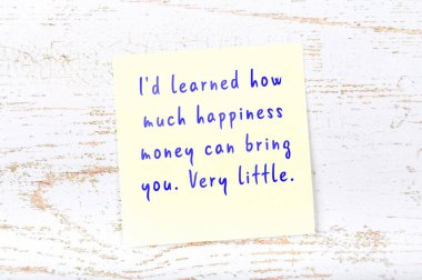 Ahşap duvardaki sarı yapışkan notta bilgece bir alıntı var.