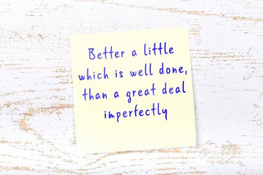 Ahşap duvardaki sarı yapışkan notta bilgece bir alıntı var.