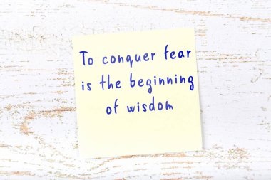 Ahşap duvardaki sarı yapışkan notta bilgece bir alıntı var.