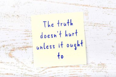 Ahşap duvardaki sarı yapışkan notta bilgece bir alıntı var.