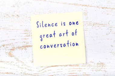 Ahşap duvardaki sarı yapışkan notta bilgece bir alıntı var.