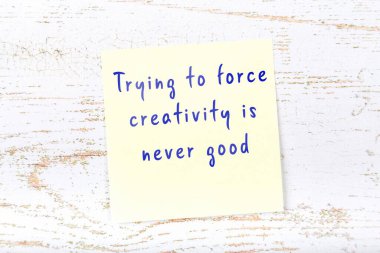 Ahşap duvardaki sarı yapışkan notta bilgece bir alıntı var.