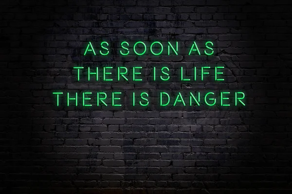 Ett klokt citat. Neon inskription mot tegelvägg — Stockfoto