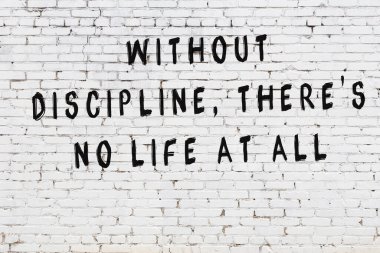 Beyaz tuğla duvar arkaplanına siyah düşünceli bir yazı.