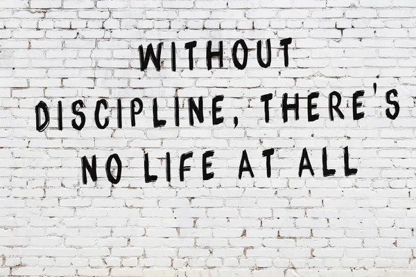 Beyaz tuğla duvar arkaplanına siyah düşünceli bir yazı.