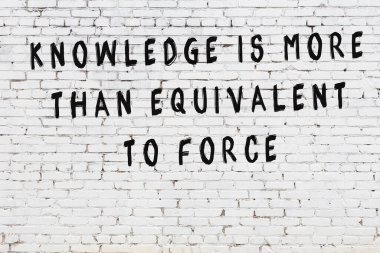 Beyaz tuğla duvar arkaplanına siyah düşünceli bir yazı.