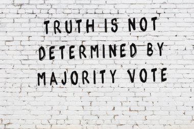 Beyaz tuğla duvar arkaplanına siyah düşünceli bir yazı.