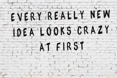 Bilgece alıntıların yazılı olduğu siyah boyanmış beyaz tuğla duvar