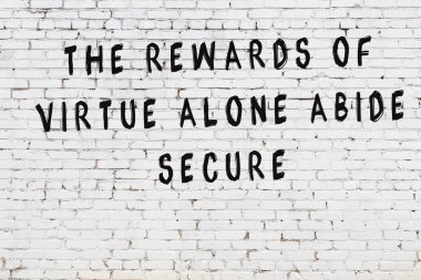 Beyaz tuğla duvara zekice alıntılar yazılı siyah bir yazı.