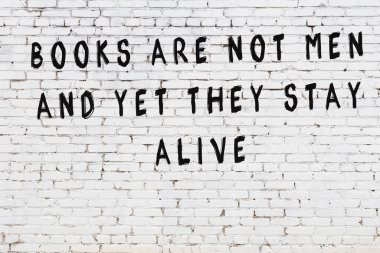 Bilgece alıntıların yazılı olduğu siyah boyanmış beyaz tuğla duvar