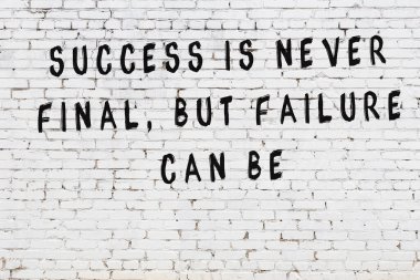 Bilgece alıntıların yazılı olduğu siyah boyanmış beyaz tuğla duvar