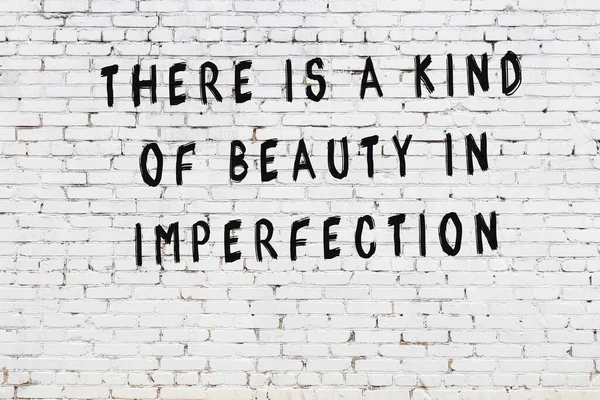 Beyaz tuğla duvar arkaplanına siyah düşünceli bir yazı.