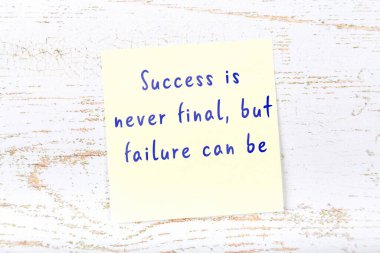 Ahşap duvardaki sarı yapışkan notta bilgece bir alıntı var.