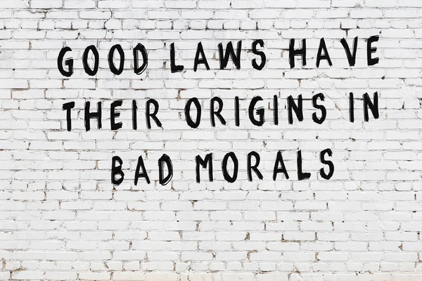 Beyaz tuğla duvar arkaplanına siyah düşünceli bir yazı.