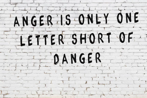 Bilgece alıntıların yazılı olduğu siyah boyanmış beyaz tuğla duvar