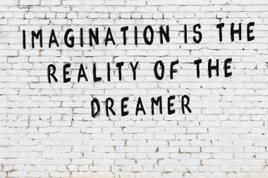 Beyaz tuğla duvar arkaplanına siyah düşünceli bir yazı.