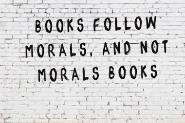 Bilgece alıntıların yazılı olduğu siyah boyanmış beyaz tuğla duvar