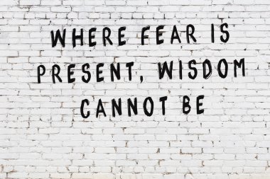 Bilgece alıntıların yazılı olduğu siyah boyanmış beyaz tuğla duvar