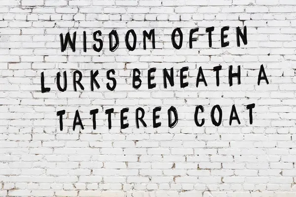 Inscription peinte en noir de citation intelligente sur un mur de briques blanches — Photo