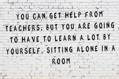 Bilgece alıntıların yazılı olduğu siyah boyanmış beyaz tuğla duvar