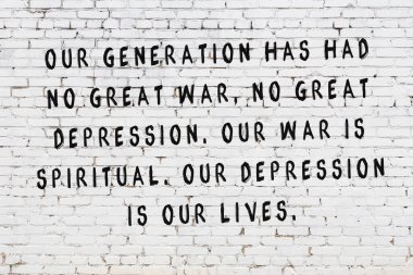 Beyaz tuğla duvara zekice alıntılar yazılı siyah bir yazı.