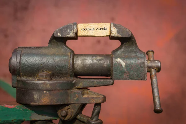 Vice grip tool squeezing a plank with the word vicious circle — Stock Photo, Image