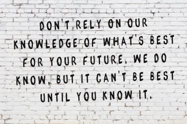 Beyaz tuğla duvar arkaplanına siyah düşünceli bir yazı.