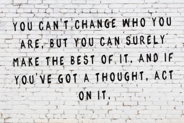 Bilgece alıntıların yazılı olduğu siyah boyanmış beyaz tuğla duvar