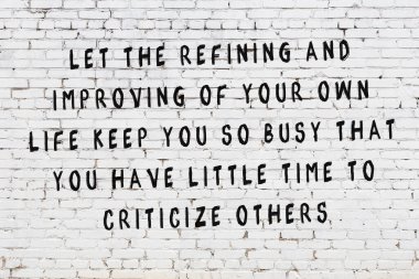 Bilgece alıntıların yazılı olduğu siyah boyanmış beyaz tuğla duvar