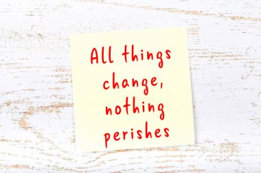 Ahşap duvardaki sarı yapışkan notta bilgece bir alıntı var.