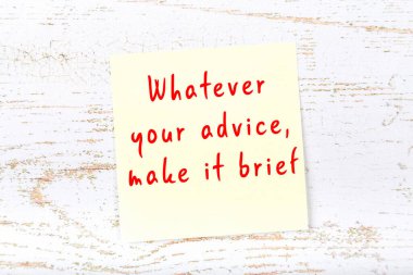 Ahşap duvardaki sarı yapışkan notta bilgece bir alıntı var.