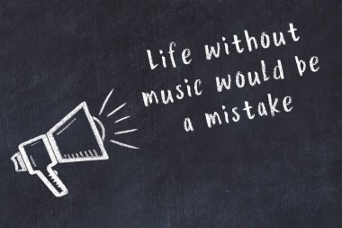 Tebeşir hoparlörü ve siyah masada akıllıca bir alıntı.