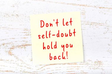 Ahşap duvardaki sarı yapışkan notta bilgece bir alıntı var.