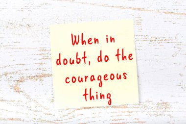 Ahşap duvardaki sarı yapışkan notta bilgece bir alıntı var.