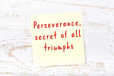 Ahşap duvardaki sarı yapışkan notta bilgece bir alıntı var.