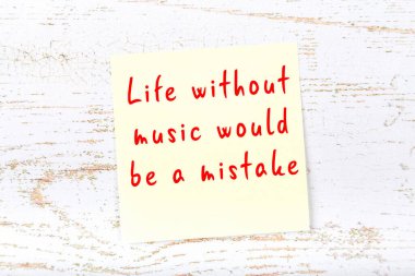 Ahşap duvardaki sarı yapışkan notta bilgece bir alıntı var.