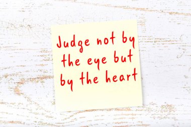 Ahşap duvardaki sarı yapışkan notta bilgece bir alıntı var.