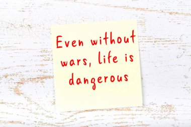 Ahşap duvardaki sarı yapışkan notta bilgece bir alıntı var.