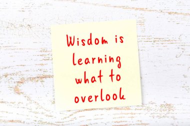 Ahşap duvardaki sarı yapışkan notta bilgece bir alıntı var.