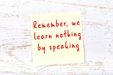 Ahşap duvardaki sarı yapışkan notta bilgece bir alıntı var.