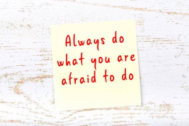 Ahşap duvardaki sarı yapışkan notta bilgece bir alıntı var.